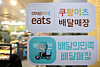 Stickers indicating that the restaurant operates Coupang Eats and Baedal Minjok delivery services are attached on a window in Seoul.