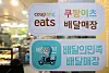 Stickers indicating that the restaurant operates Coupang Eats and Baedal Minjok delivery services are attached on a window in Seoul.