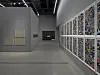 Museum or gallery corridor with framed art on one side and colorful wall-mounted artworks on the other.