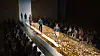 Samsung Bespoke Jet AI vacuum on a runway-style stage covered with gold-colored debris.
