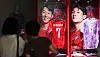 People look at Korea Football Association national team jerseys displayed in a pop-up store window.