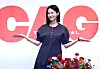 Ivy stands in front of a Chicago backdrop at a Seoul press event with her arms slightly outstretched.