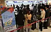 Air travelers queue to check in for a flight heading to Japan at Gimpo International Airport in western Seoul on Oct. 11, 2022.