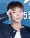 Park Ji-hoon poses in front of a blue event backdrop at a Seoul press conference.