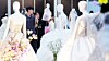 Visitors at a wedding fair at Coex in Gangnam District, southern Seoul, look at wedding dresses on July 6, 2025.