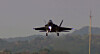 KF-21 Boramae fighter jet flying low over a hazy landscape during a test flight.