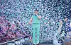Psy performs onstage in mint green clothing as confetti fills the air behind him.