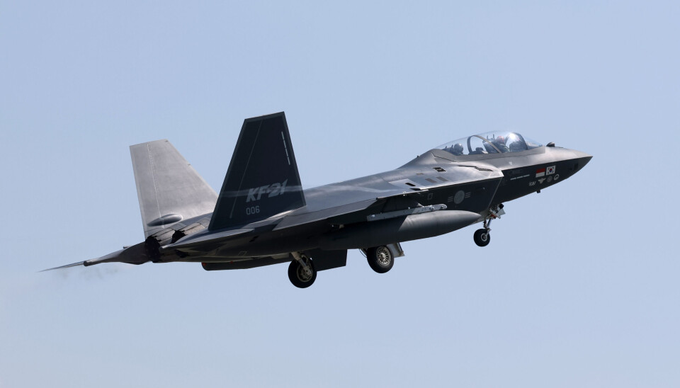 KF-21 prototype fighter jet flying against a clear blue sky.