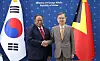 Two foreign ministers stand side by side in front of South Korean and East Timorese flags at a formal meeting.