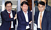 Three South Korean lawmakers walk out of a meeting room doorway inside the National Assembly.