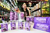 7-Eleven display featuring ube drinks, snacks and desserts in a store aisle.