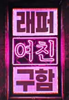 Vertical pink neon sign with Korean characters on a dark background.