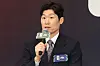 Park Ji-sung holding a microphone and speaking at a news conference backdrop.