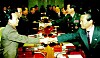 Delegates from North and South Korea shake hands across a conference table during a formal meeting.