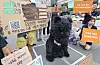 Protesters in Seoul display signs beside a person in a bear costume during a rally.
