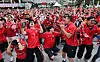 Crowd of football fans in red jerseys cheering at a public viewing in Seoul.