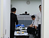 Officials in a government office with tables covered in documents, water bottles, and cups during a search.