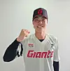 A smiling baseball player in a Lotte Giants uniform poses with a raised fist against a plain background.
