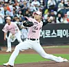 Hanwha Eagles pitcher Wang Yan-cheng throws a pitch during a game with fans in the stands behind him.