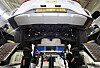 Workers change a battery pack under an electric taxi inside a battery swap station.