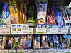 Assorted snack and energy bars arranged in a store cooler with price labels.