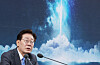 South Korean President Lee Jae-myung speaks at a podium with a space-themed backdrop.