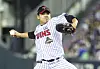 A baseball pitcher in an LG Twins uniform throws a pitch on the mound at a stadium.