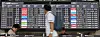 People walk in front of a large domestic flight information board at Gimpo International Airport.