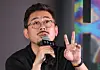 Director Na Hong-jin holds a microphone and gestures while speaking at a press screening event.