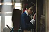 Roh Yoon-seo in blue period clothing stands in a narrow palace corridor, touching the wall.