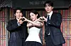Three actors pose together in front of a stage backdrop at a Netflix series production event.