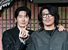 Two men pose in front of a patterned backdrop at a Netflix series press event in Seoul.