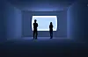 Two people in silhouette stand in a dim blue room facing a bright rectangular opening.