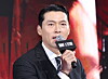 Actor Hyun Bin holds a microphone and speaks at a Disney+ drama production event.
