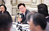 President Lee Jae Myung speaks at a meeting table with microphones and officials seated nearby.