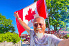 Dong Guangping poses for a photo with the Canadian flag after arriving in Toronto, Canada, on June 27.
