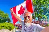 Dong Guangping poses for a photo with the Canadian flag after arriving in Toronto, Canada, on June 27.