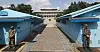 Soldiers stand guard between two blue buildings at Panmunjom.