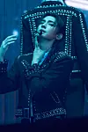 Myeong Jaehyun onstage in black clothing with a lighted hat and blue lighting.