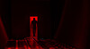 A silhouetted person stands in a dark corridor with red lighting and a reflective patterned floor.