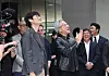 Jensen Huang and Lee Hae-jin stand outdoors with several people, smiling and greeting employees at Naver headquarters.
