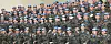 Rows of uniformed peacekeepers in blue helmets pose for a group photo indoors.