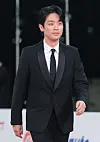 Actor Park Jung-min in a black suit walks the red carpet at the Blue Dragon Film Awards in Seoul.