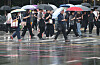 Pedestrians walk on the street while holding umbrellas in central Seoul on July 20.