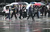 Pedestrians walk on the street while holding umbrellas in central Seoul on July 20.