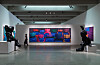 Modern museum gallery with a bright neon artwork, sculptures, and visitors in a spacious exhibition hall.
