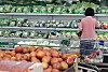 Shoppers browse vegetables and fruit in a Seoul supermarket produce section.