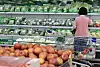 Shoppers browse vegetables and fruit in a Seoul supermarket produce section.