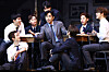 Actors perform a rehearsal scene around a table during a press preview for 'Dead Poets Society' in Seoul.