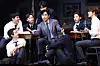 Actors perform a rehearsal scene around a table during a press preview for 'Dead Poets Society' in Seoul.